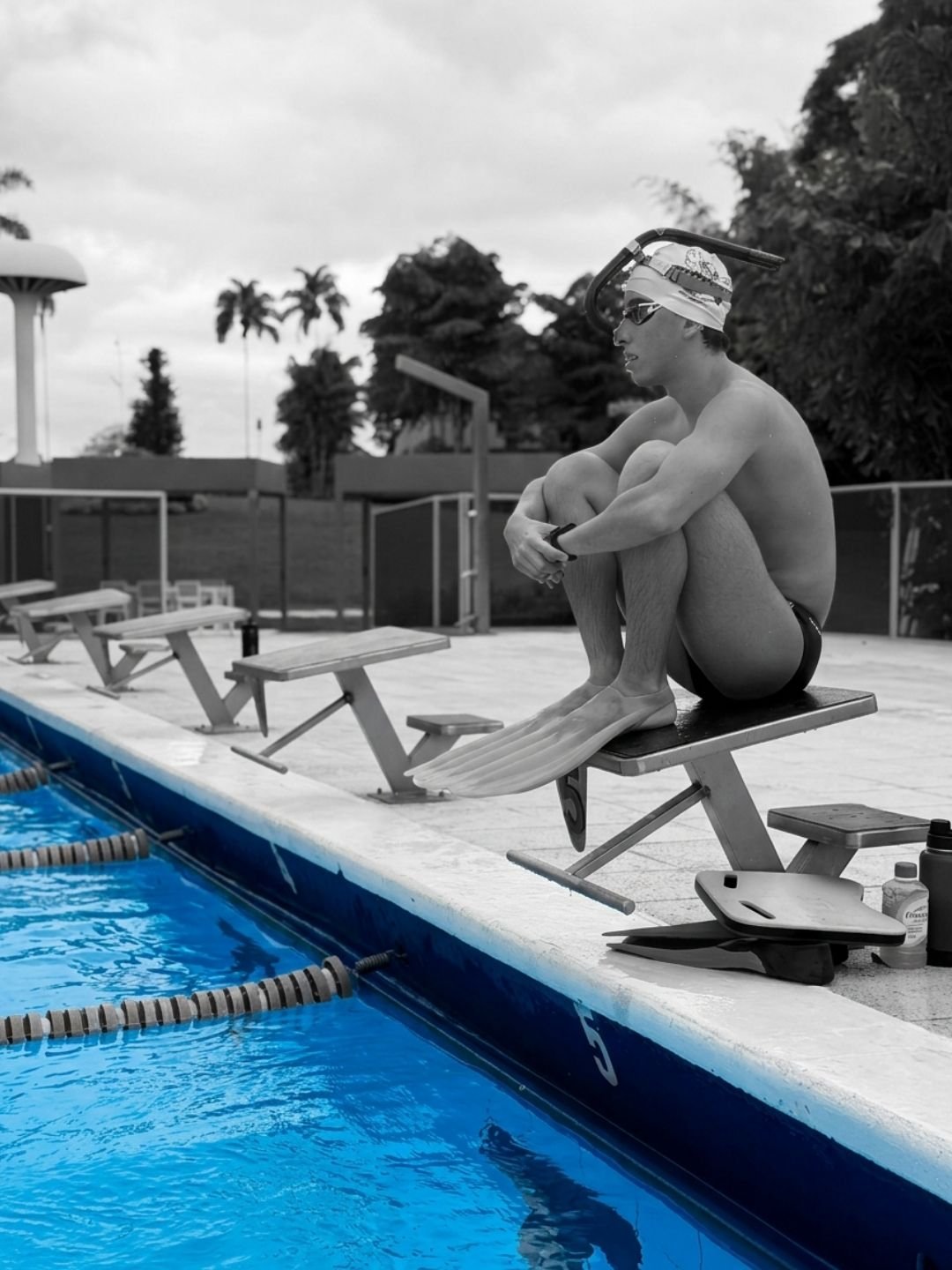 Konsta sitting on the starting block with his monofin before entering the water